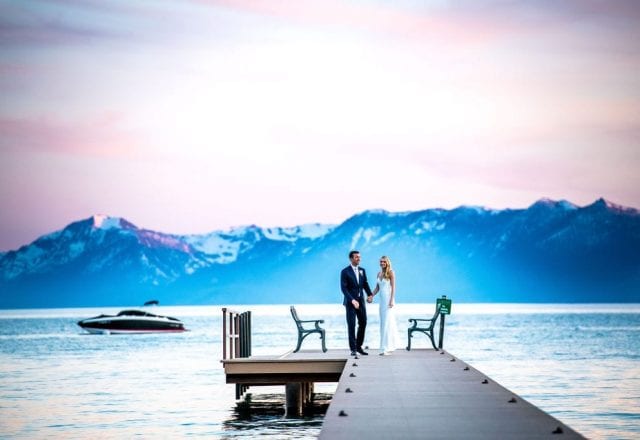 Bride and groom on Lake Tahoe dock with boat in the background